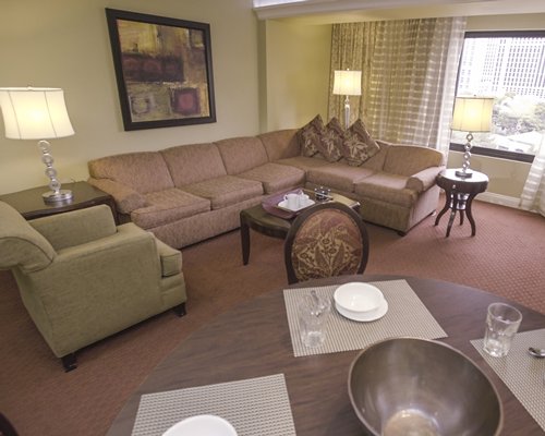 An open plan bedroom with a king bed dining area and an outside view.