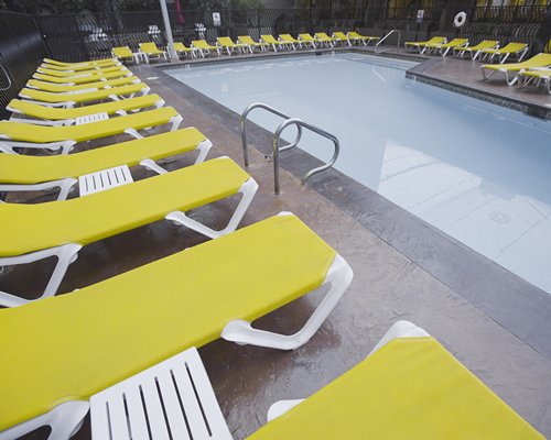 Outdoor swimming pool with chaise lounge chairs and beverages.