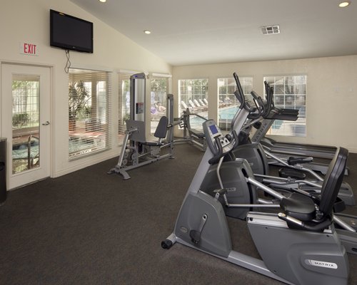 A well equipped fitness center with television.