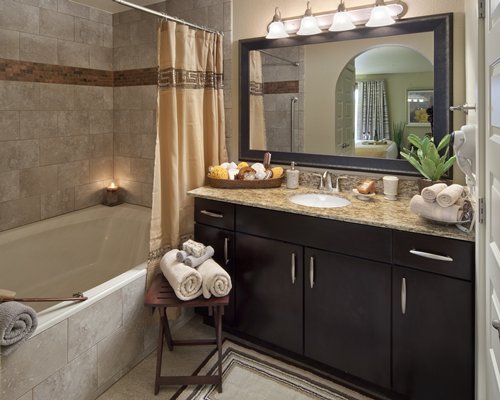 A bathroom with single sink vanity and a bathtub.