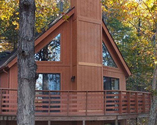 Exterior view of a unit with deck surrounded by woods.