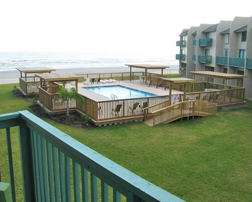 An outdoor swimming pool alongside multiple townhouses with private balconies.