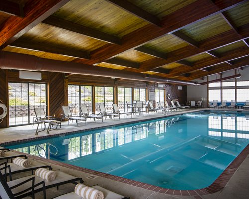 A large indoor swimming pool with lounge access.