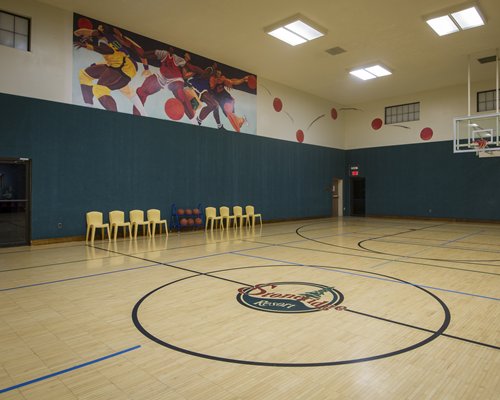An indoor basket ball court along with chairs.