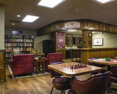 An open plan kitchen alongside a library and chess board tables.