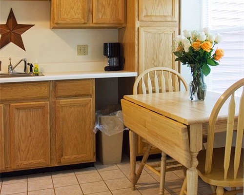 A well equipped kitchen and wooden dining table.