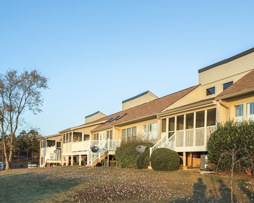 Outside view of multiple units surrounded by trees and shrubs.