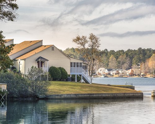 A lake view of Fairfield Plantation resort surrounded by lawns and trees.