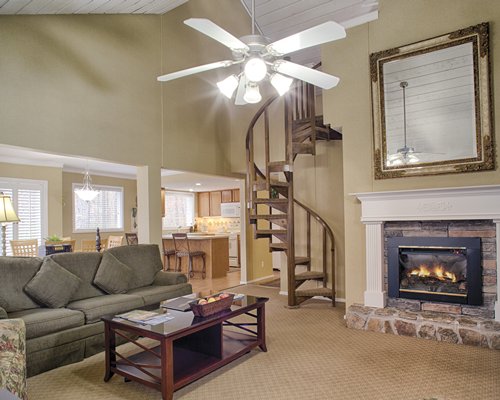 A well furnished living room with a spiral staircase and fireplace.