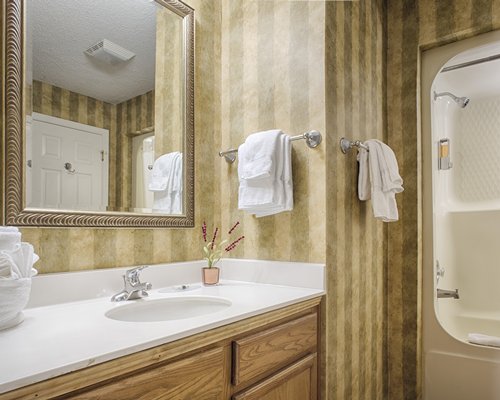 A bathroom with a shower and a single sink vanity.