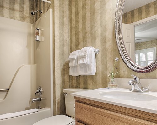 A bathroom with shower and a single sink vanity.