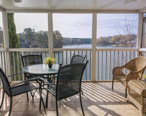 A balcony area with a view of the lake and woods.