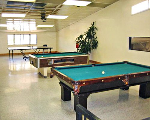 An indoor playing area wit table tennis and pool tables.