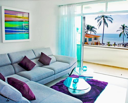 A furnished living room facing the ocean with a balcony.