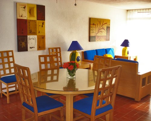 An open plan furnished living room with sofa and dining area.