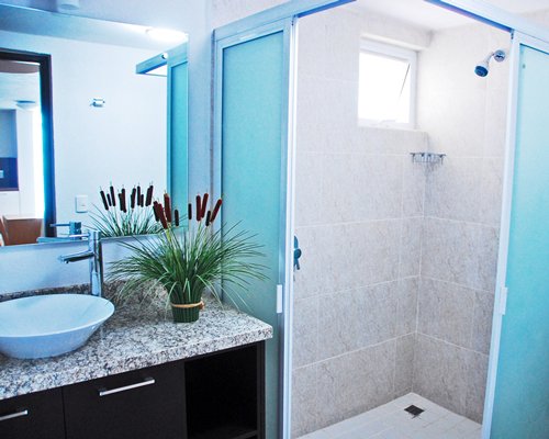 A bathroom with single sink vanity and a stand up shower.