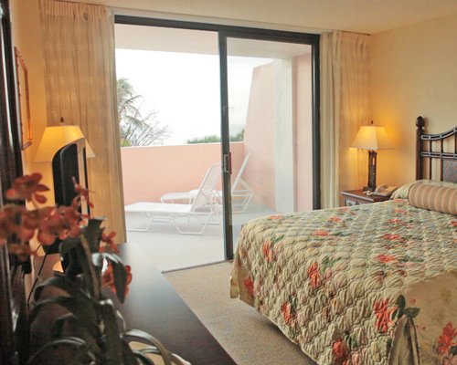 A well furnished bedroom with a bed and a balcony.