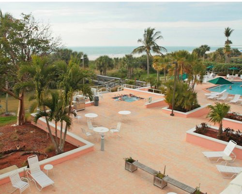 An aerial view of outdoor picnic area with hot tub chaise lounge chairs and swimming pool.