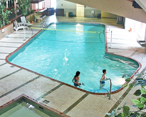 An outdoor swimming pool with chase lounge chairs.