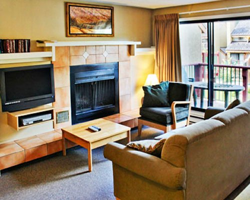 A furnished living room with fireplace television and balcony.