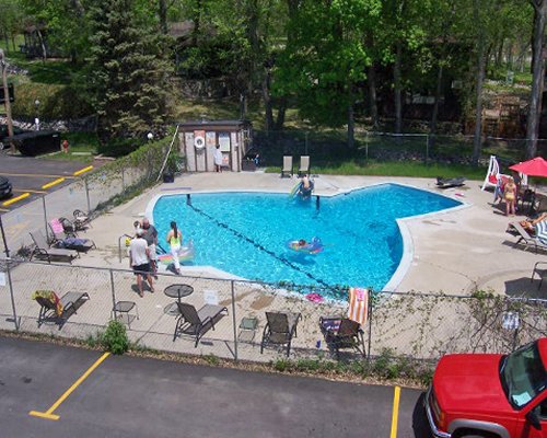 An aerial view of an outdoor swimming pool with chaise lounge chairs.