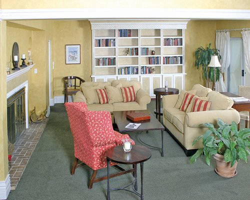 A well furnished living room with a fireplace and book shelf.