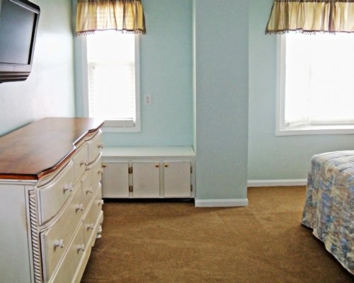 Furnished bedroom with television and outside view.