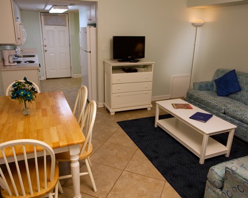 Living room with open plan kitchen dining area and television.