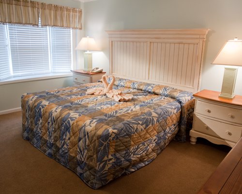 A well furnished bedroom with a queen size bed and an outdoor view.