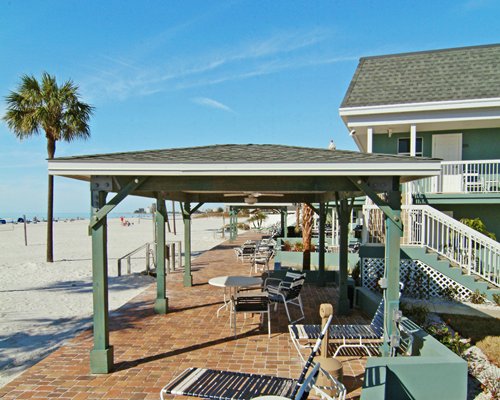An outdoor area with chaise lounge chairs and sunshades along the beach.