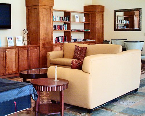 A well furnished living room with television and book shelf.