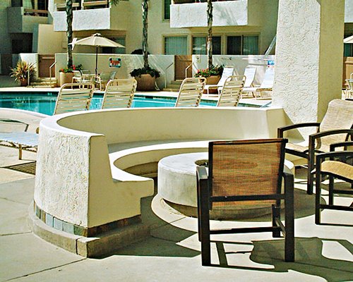 An outdoor dining area alongside a swimming pool and chaise lounge chairs.