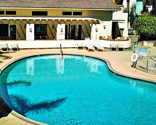 An outdoor swimming pool with chaise lounge chairs.