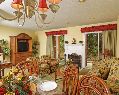 A well furnished living room with dining area fireplace and outdoor view with patio.