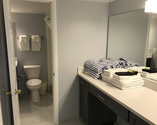 A bathroom with shower bathtub and single sink vanity.