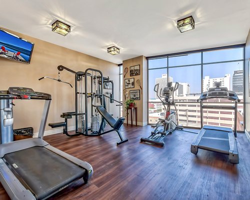 A well equipped fitness center with outside view.