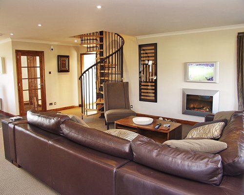 A well furnished living room with a stairway and outside view.
