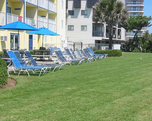 Scenic exterior view of Jade Tree Cove with sunshades and chaise lounge chairs.