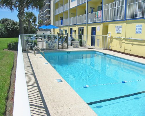 Scenic outdoor swimming pool alongside multi story balconies.