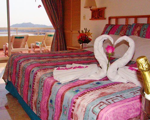 Two towels crafted as a heart placed on a bed.