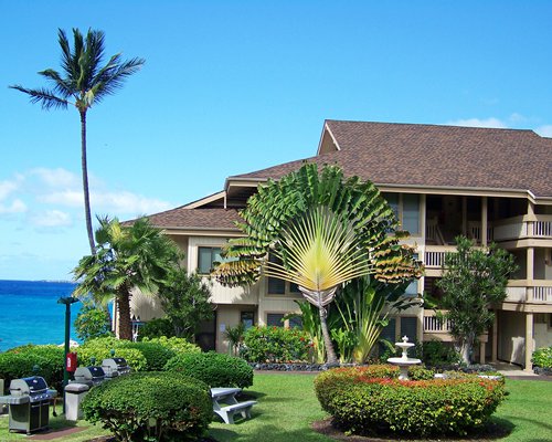 Exterior view of Vacation Internationale Sea Village by landscaping alongside ocean.