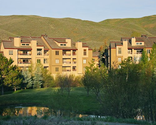 A view of multi story units and mountains surrounded by woods.