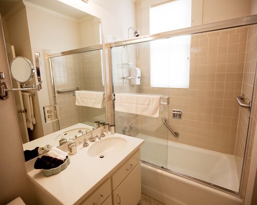 A bathroom with a shower bathtub and a single sink vanity.