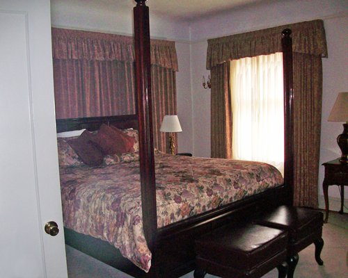 A well furnished bedroom with a queen bed and an outdoor view.