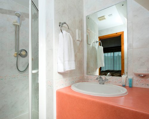 A bathroom with stand up shower and single sink vanity.