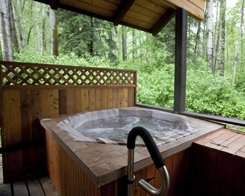 A wooden hot tub surrounded by trees.