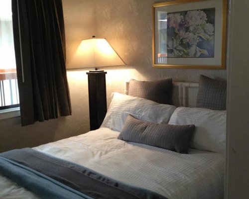 A well furnished bedroom with king bed and outside view.