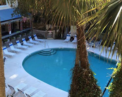 A scenic view of an outdoor swimming pool with chaise lounge chairs.