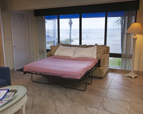 Living room with pull out queen couch and outside beach view.