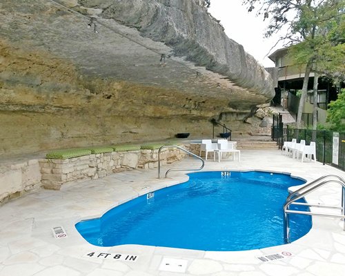 An outdoor hot tub with patio furniture.